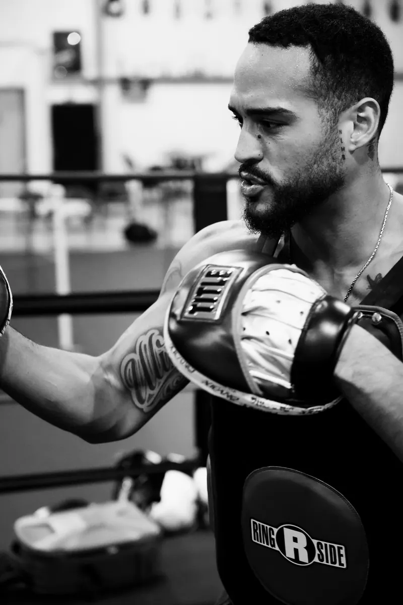 Jeremiah Sierra holding mitts in a body protector at Toe 2 Toe Boxing