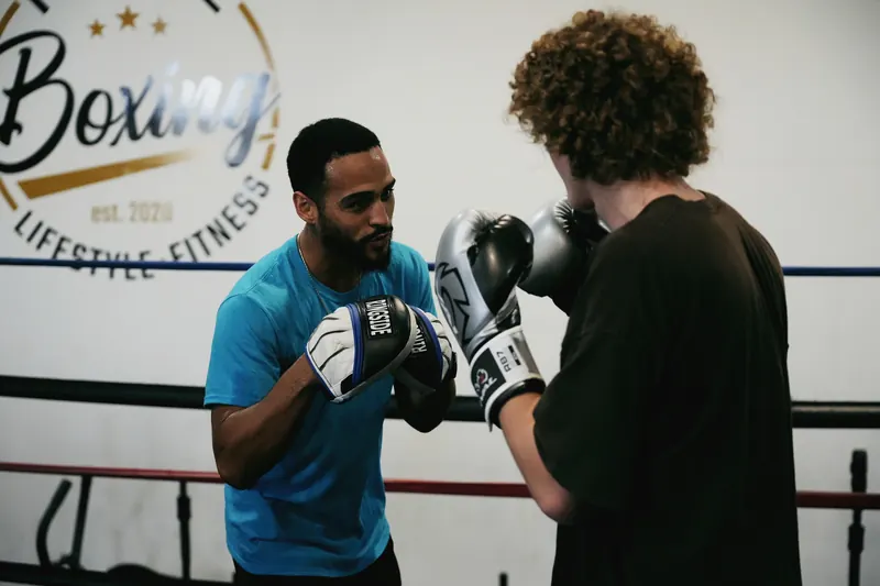 Jeremiah running pad work with a client at Toe 2 Toe Boxing